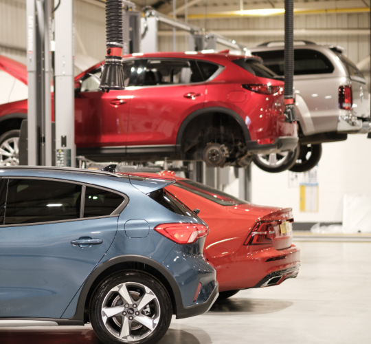 Cars lined up in a car service workshop; manufacturer servicing