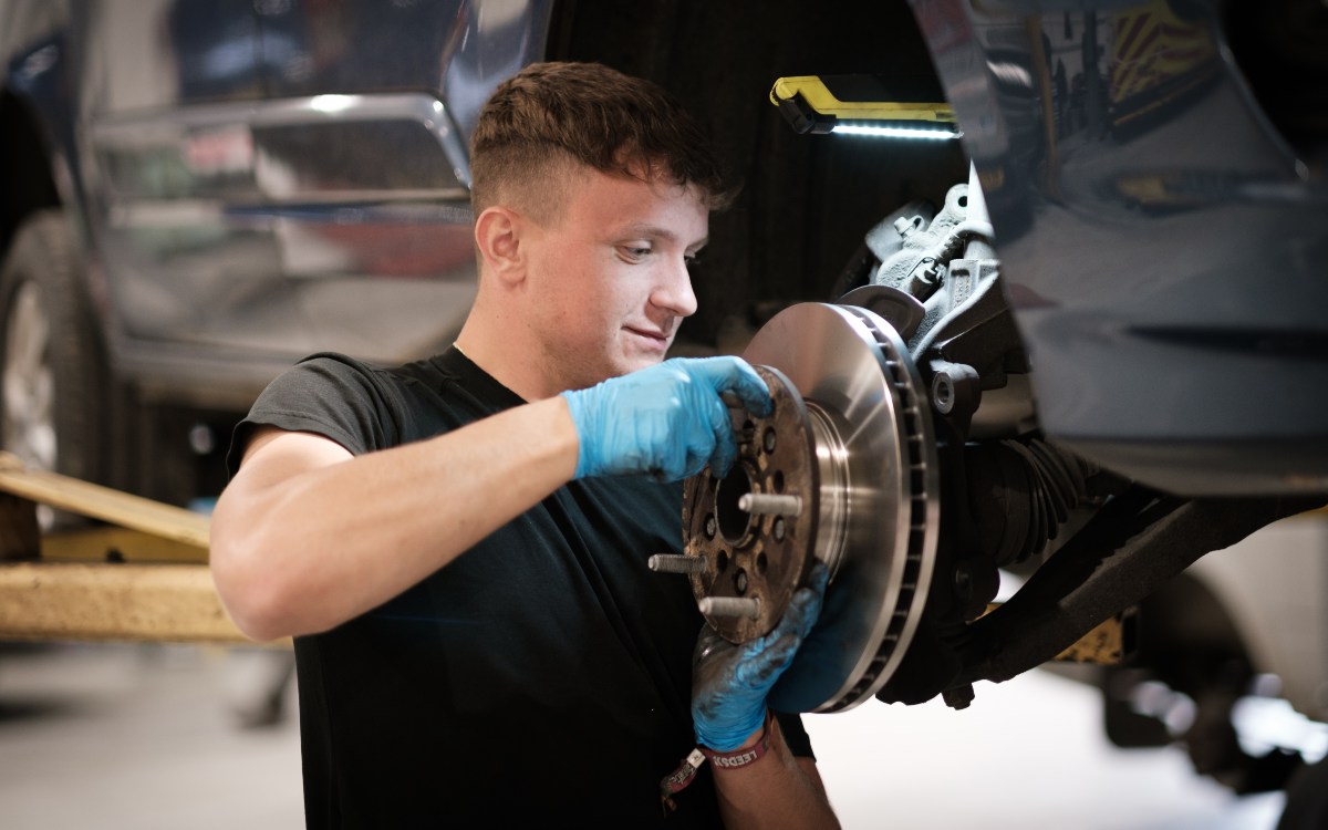 A technician performs checks on a car's brake