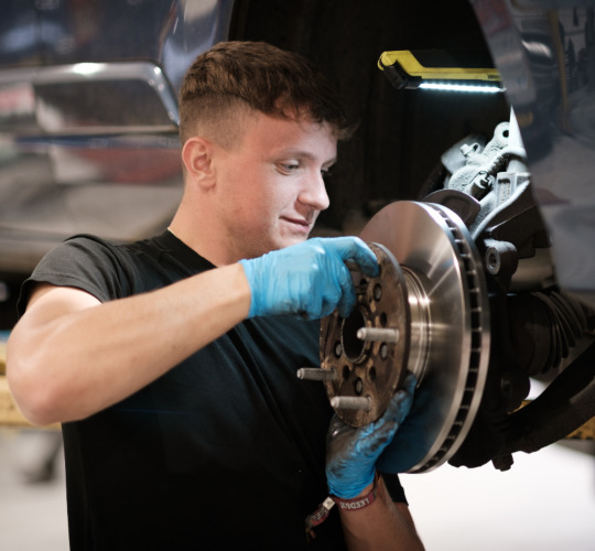 A technician performs checks on a car's brake