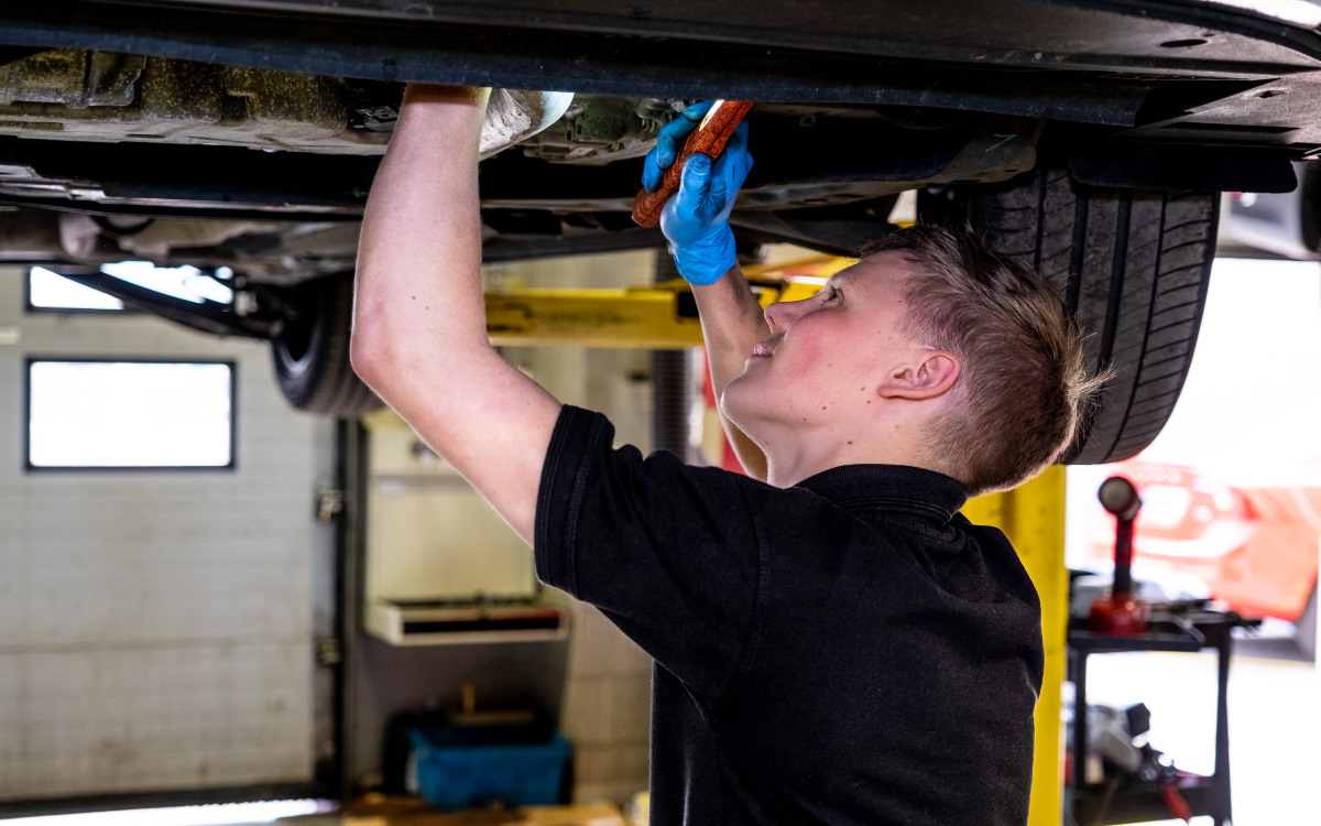 A technician checks a car's components during a service