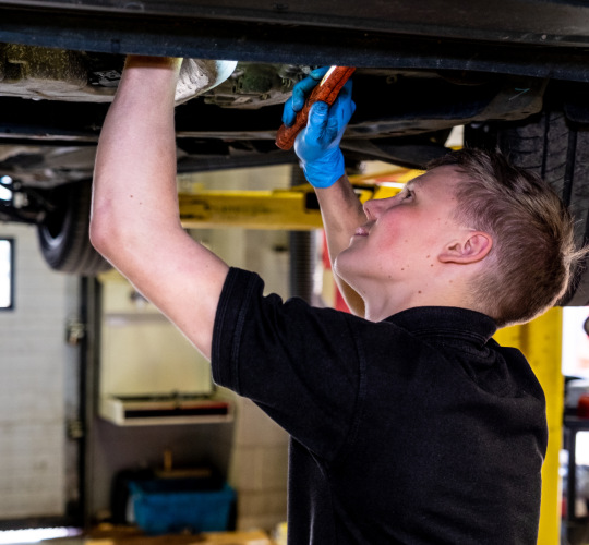 A technician checks a car's components during a service