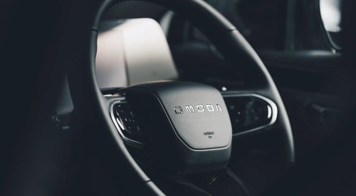 Close-up shot of an OMODA branded steering wheel.