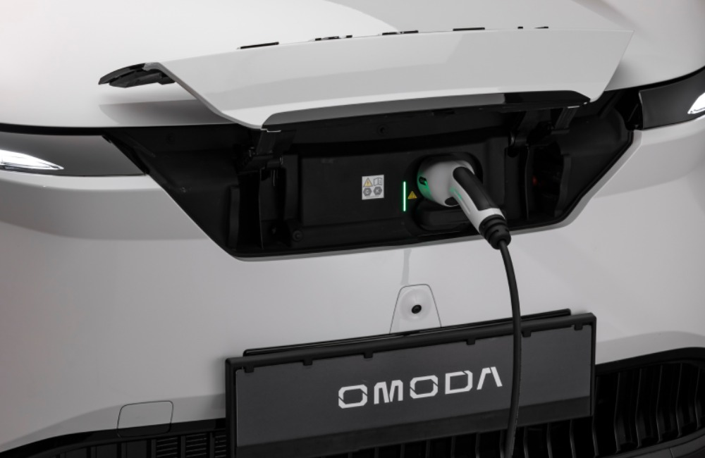 Front of an electric OMODA car with an externa charger plugged in