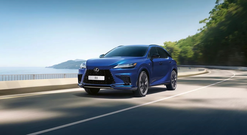 Lexus RX Plug-in Hybrid in Pearlescent Azure Blue driving along a coastal road.