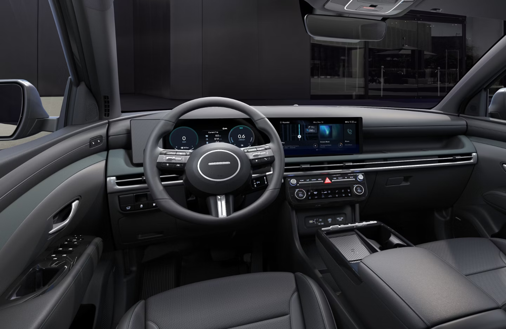Interior show of a new Hyundai TUCSON from the perspective of the driver, showing off the steering wheel, centre console, and infotainment system.