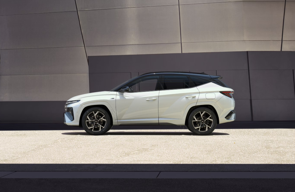 Side profile of a new Hyundai TUCSON N Line Edition, boasting the white and black colours, alongside the alloy wheels and bold styling.
