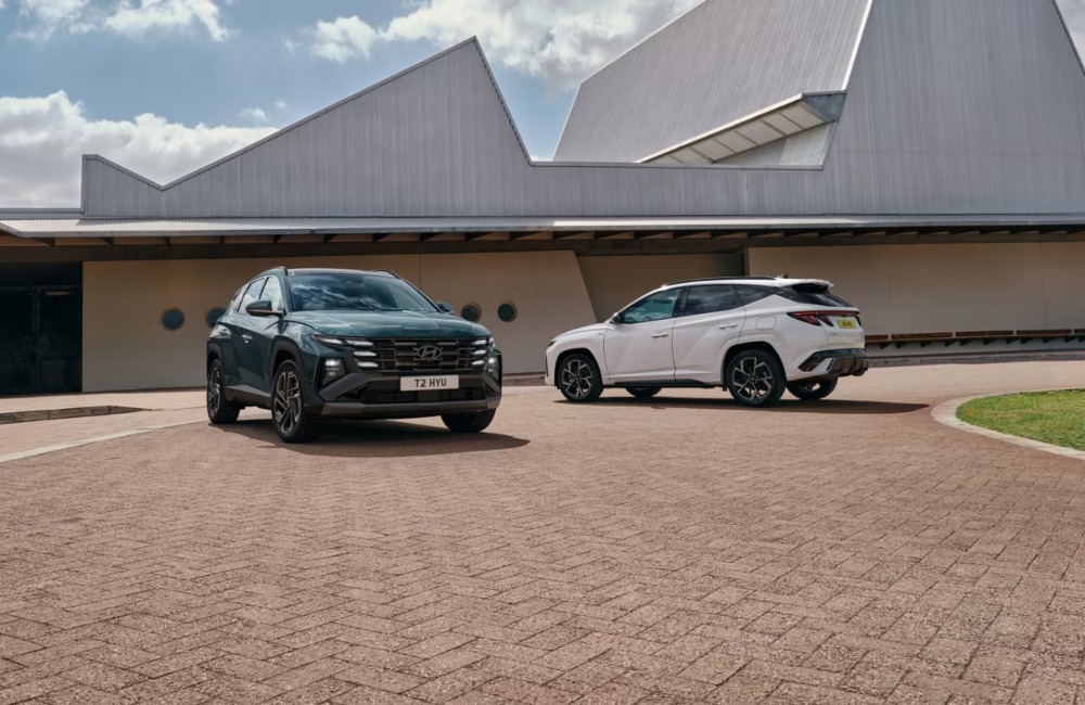 Two Hyundai TUCSON Hybrid cars parked next to one another, with focus on the front and rear designs on the vehicles.
