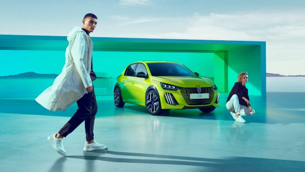 New Peugeot 208 for sale in Agueda Yellow, parked next to two people.