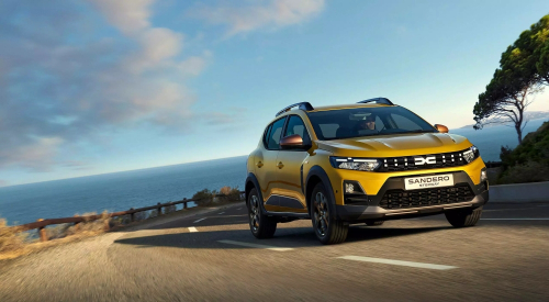 Amber Yellow Dacia Sandero Stepway driving along a coastal road.