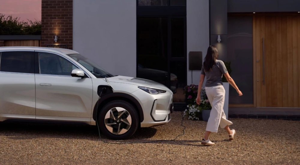 A person charging the Geely EX5 at home; Second-hand Geely EX5 for sale