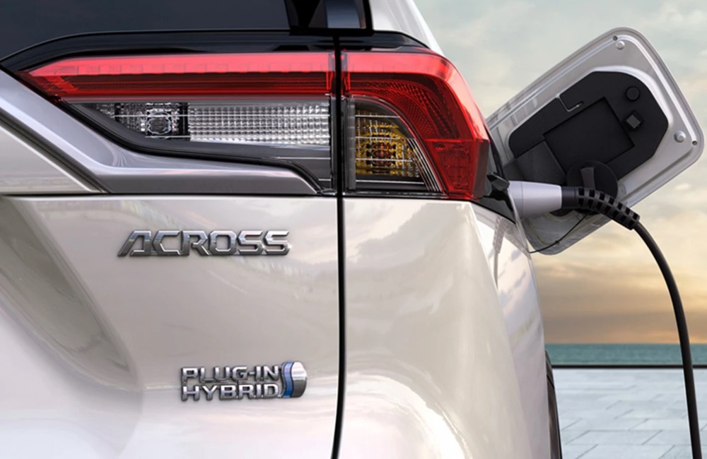 Close-up rear shot of the new Suzuki Across as it is plugged in and charging. The shot shows the Across badging, alongside Plug-in Hybrid branding,