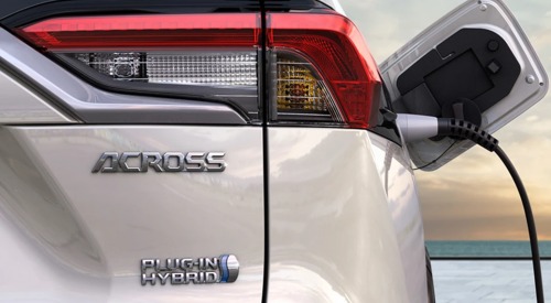 Close-up rear shot of the new Suzuki Across as it is plugged in and charging. The shot shows the Across badging, alongside Plug-in Hybrid branding,