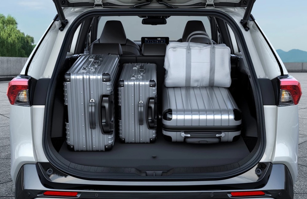 Rear shot of an open-boot Suzuki Across. The boot is filled with multiple suitcases and luggage bags to show how much space the boot can hold.