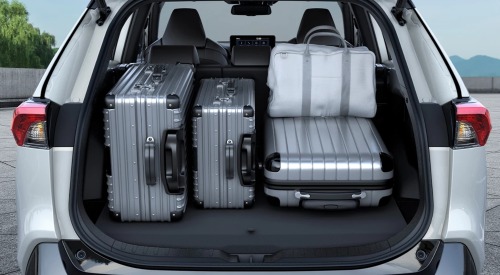 Rear shot of an open-boot Suzuki Across. The boot is filled with multiple suitcases and luggage bags to show how much space the boot can hold.