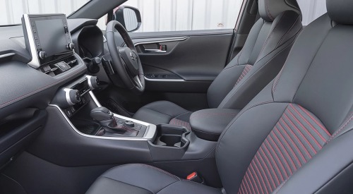 Interior of a new Suzuki Across showing off the comfortable front seats and advanced infotainment system.