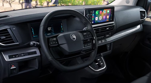 Interior shot of the drivers wheel, infotainment system, digital clusters, and centre console of a used Citroen Dispatch.