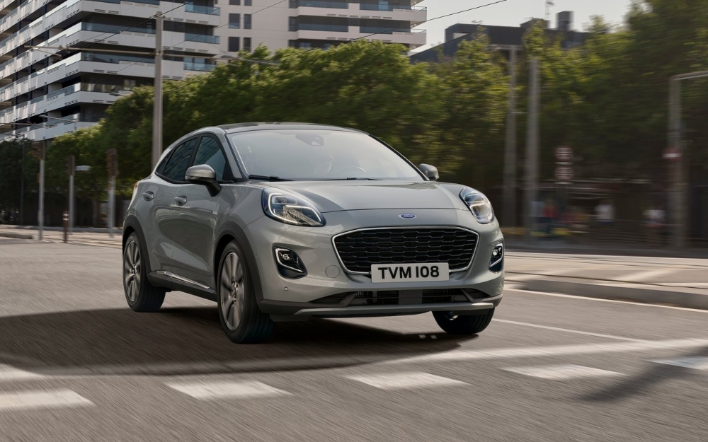 Used Ford Puma in Solar Silver, driving down a city street.