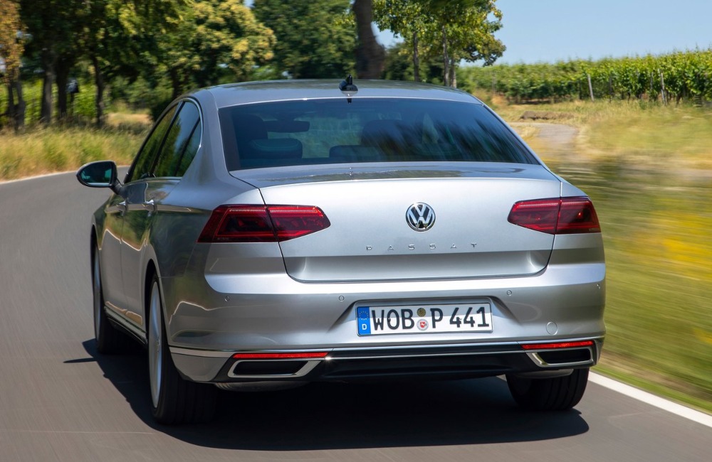 Rear shot of a VW Passat driving at speed down a country road.