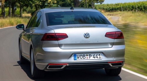 Rear shot of a VW Passat driving at speed down a country road.