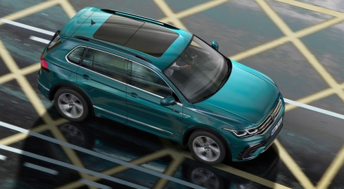 Angled top down shot of a Volkswagen SUV driving at speed down a city road.