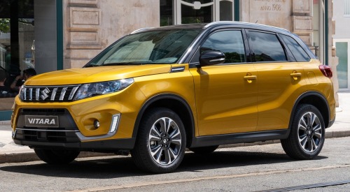 Angled side view of a used Suzuki Vitara parked on a city road.