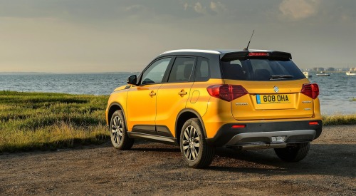 Angled rear shot of a used Suzuki Vitara parked on a cliff overlooking the ocean.