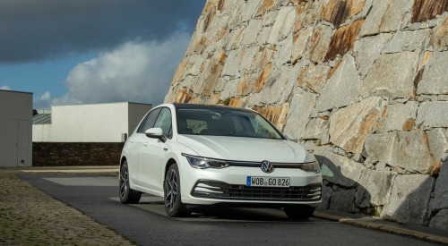 VW Golf parked on a road next to a rock side.