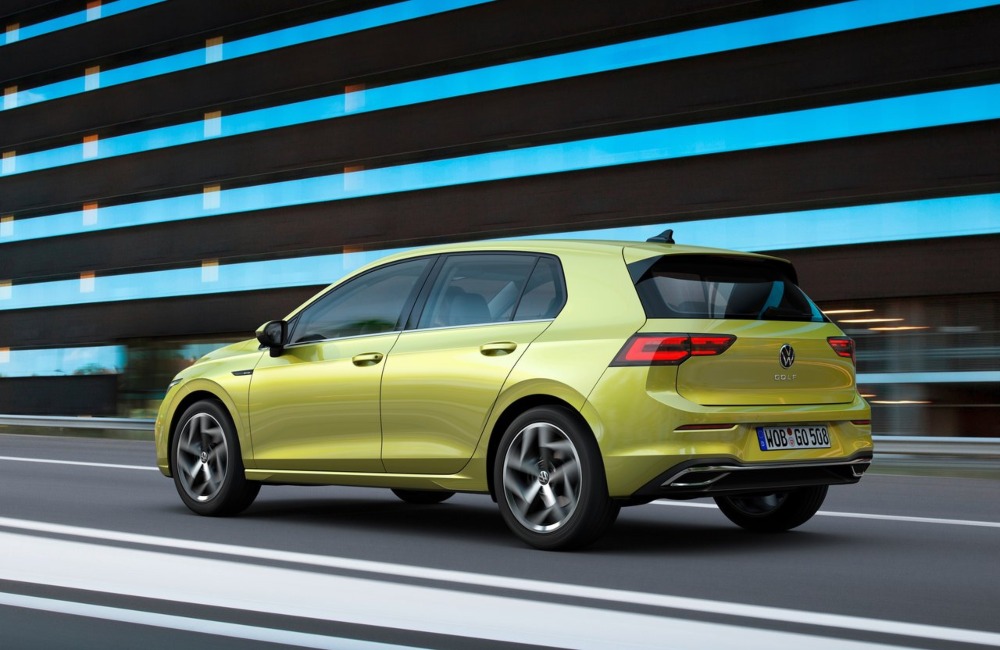 An angled back shot of a used VW Golf driving at speed down a city road.