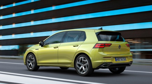 An angled back shot of a used VW Golf driving at speed down a city road.