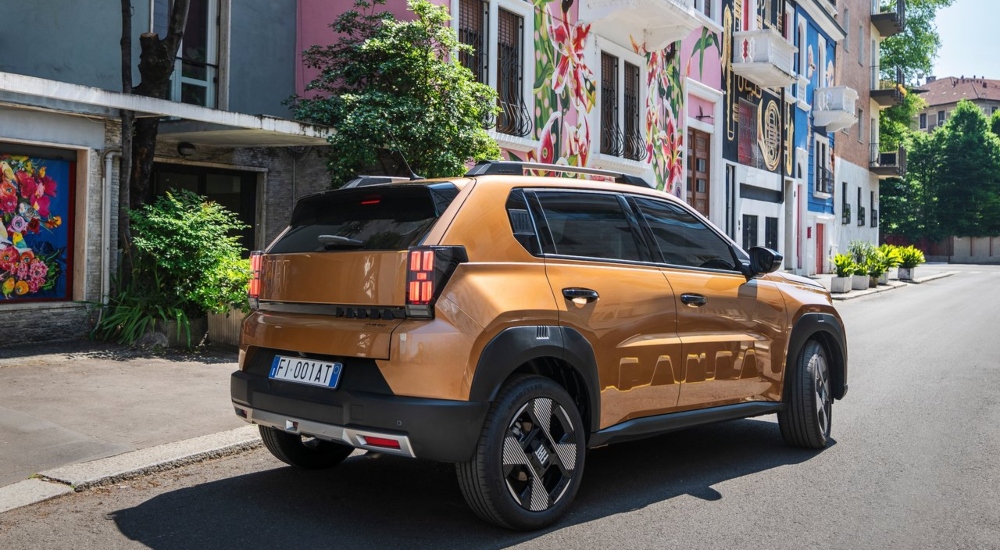 The new Fiat Grande Panda Hybrid in Lunar Bronze driving down a road; New Fiat Grande Panda Hybrid performance