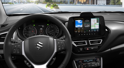 Interior shot of a new Suzuki S-Cross from the drivers perspective, showing off the steering wheel and infotainment system.