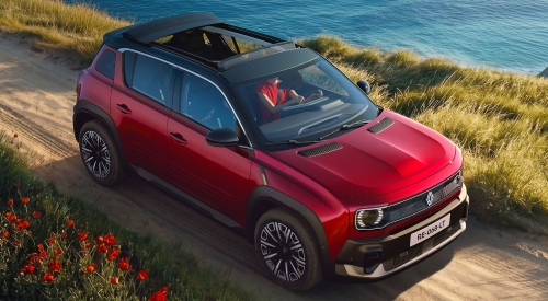 A red Renault 4 Plein Sud parked on a cliffside with the canvas roof folded down, surrounded by grass and greenery.