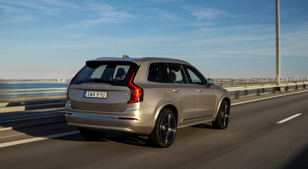 A Volvo XC90 Plug-in Hybrid driving down a road rear view; Used Volvo XC90 Plug-in Hybrid finance deals