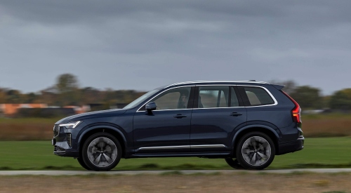 Side view of a Volvo XC90 Plug-in Hybrid driving down a road; Volvo XC90 Plug-in Hybrid used car for sale