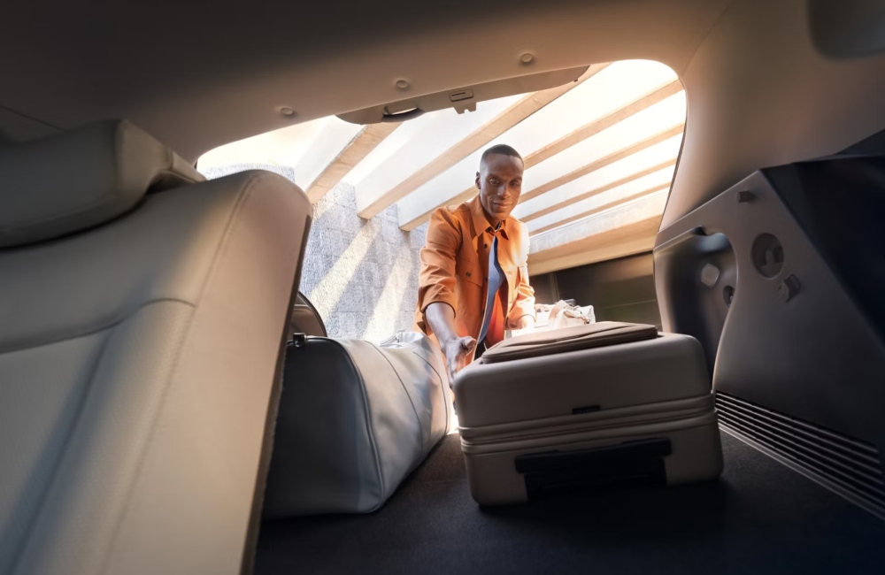 A personal loading luggage into the boot of a new Hyundai KONA Electric.