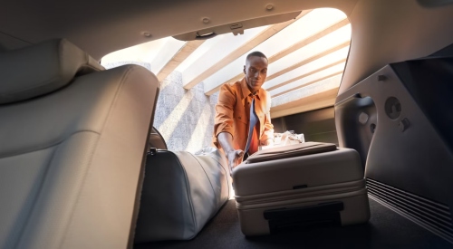 A personal loading luggage into the boot of a new Hyundai KONA Electric.