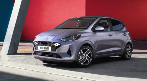 Angled front shot of a new Hyundai i10 parked on the side of the road, showing off the LED lighting and unique design.