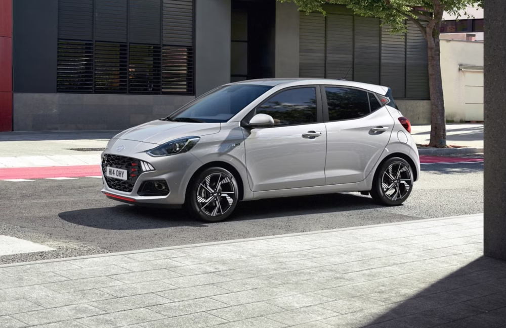 Angled side shot of a new Hyundai i10 N Line parked outside a modern building.