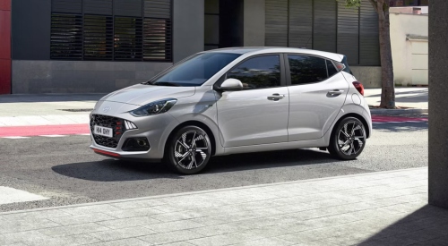 Angled side shot of a new Hyundai i10 N Line parked outside a modern building.