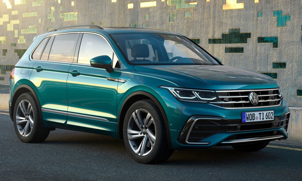 Green Volkswagen SUV parked next to a modern building.