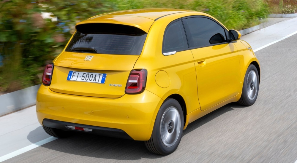 Rear view of the New Fiat 500 Hybrid as it drives along a road; Fiat New 500 Hybrid