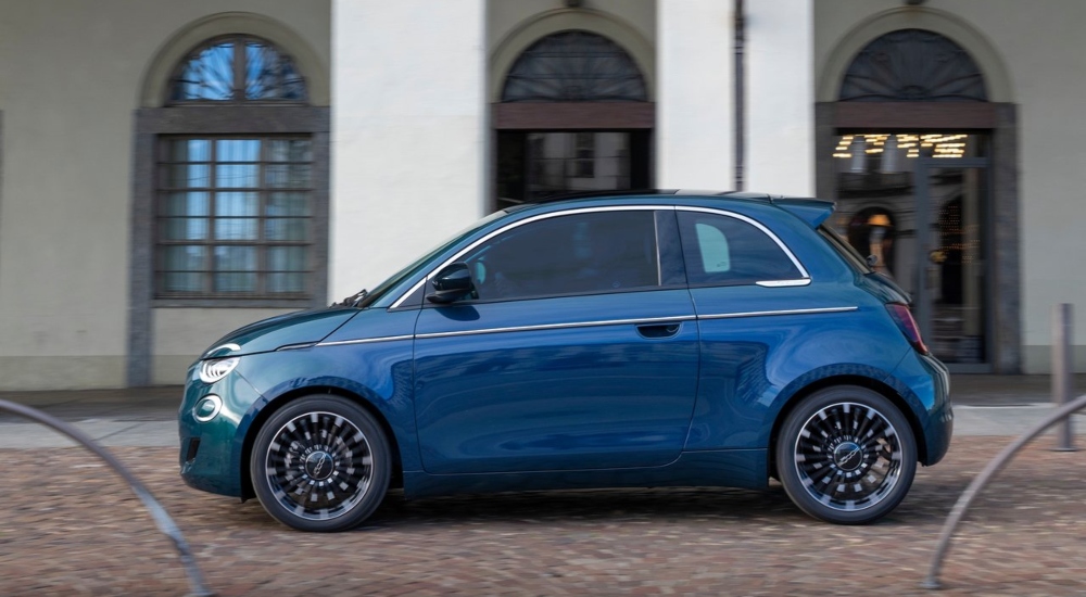 A blue Fiat 500 Hybrid driving a long a cobbled street; New Fiat 500 Hybrid Finance Deals