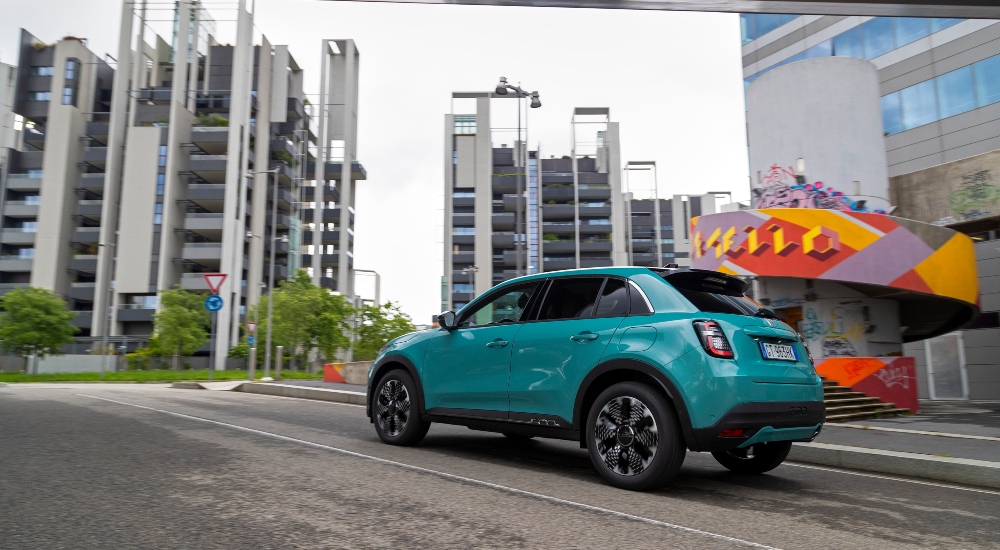A Fiat 600 Hybrid in Sky Blue driving down a road; New Fiat 600 Hybrid UK