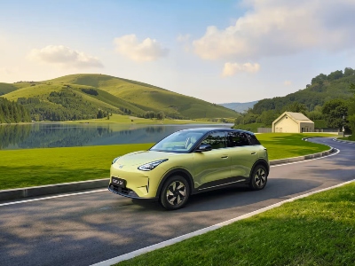 A Geely EX2 in Aurora Green driving along a road; New Geely EX2 Car for Sale