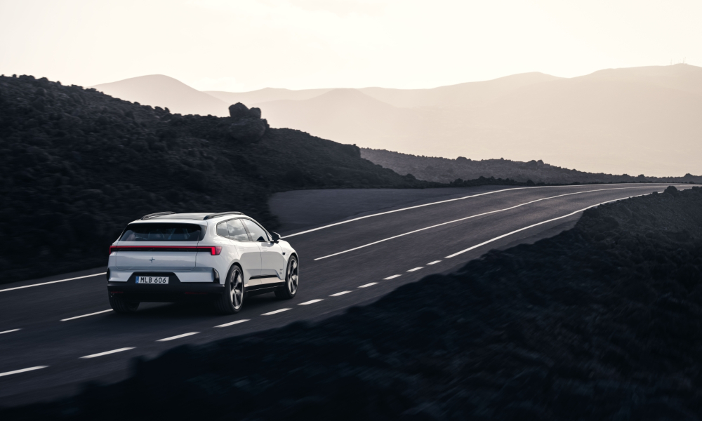 New Polestar 4 SUV driving along an open road at sunset