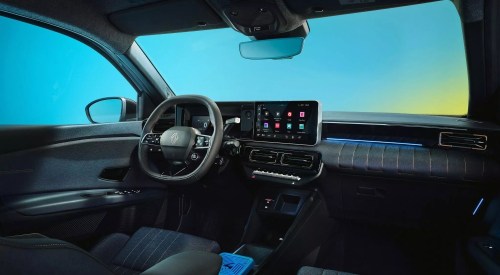 Interior shot of a new Renault 4, showing off the driving position and infotainment system.