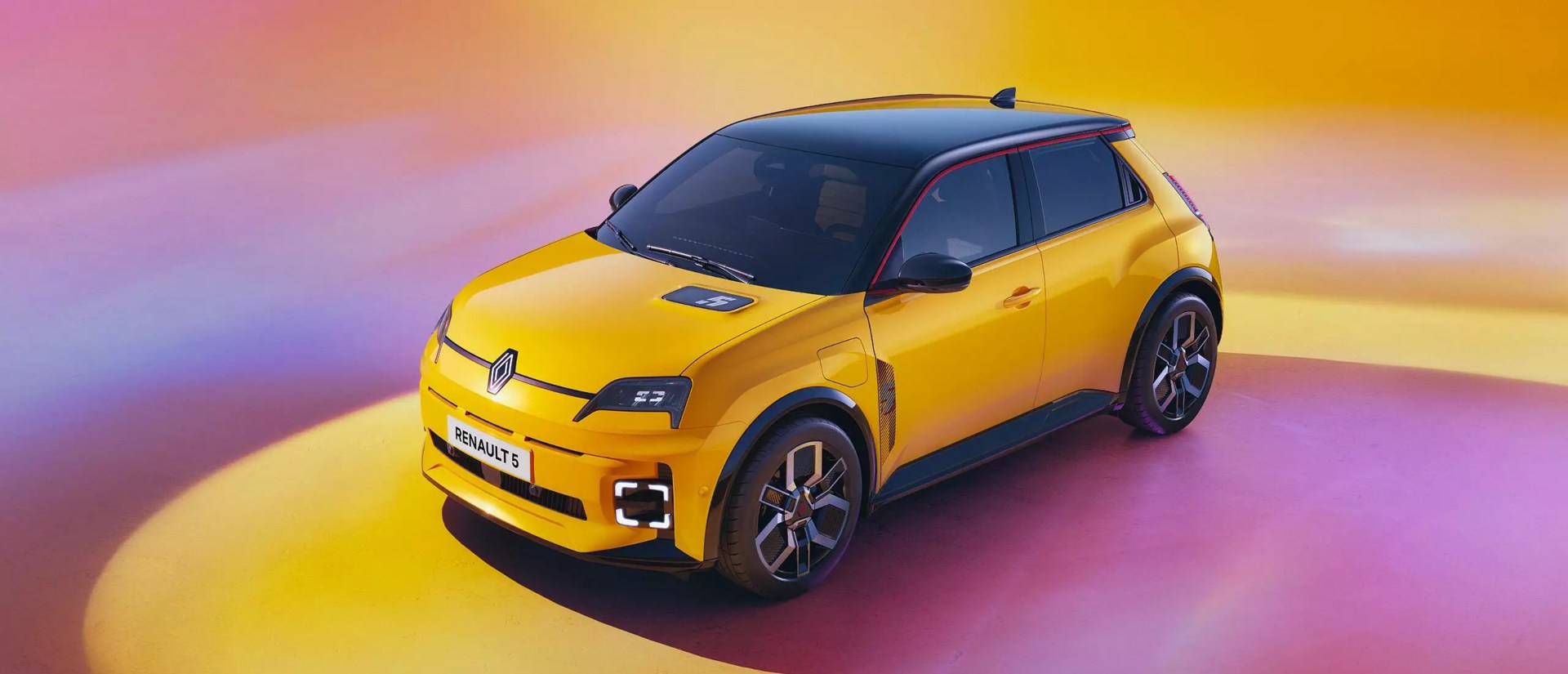 Photoshoot of a yellow Renault 5, showing off the LED lighting and unique design. The car is surrounded with a colourful purple and yellow backdrop.