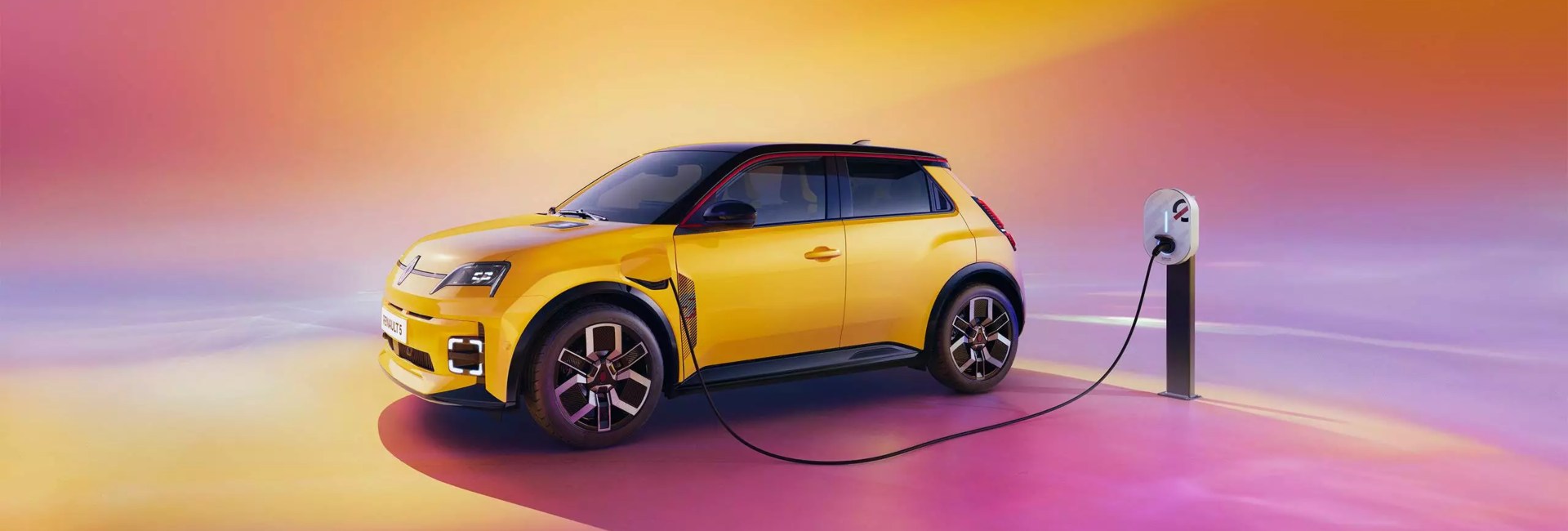 A yellow Renault 5 plugged in and charging.