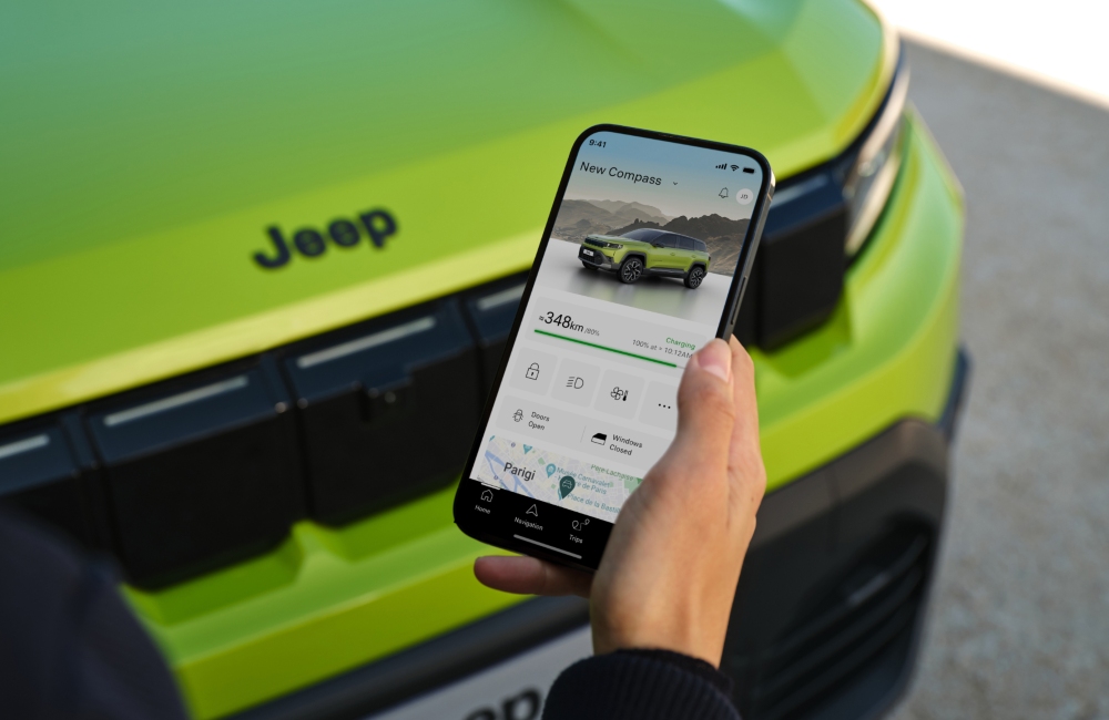 Person charging a Jeep Compass electric car from their phone