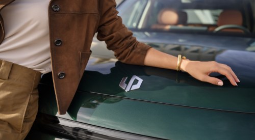 A close up shot of a person leaning on a Leapmotor car, showing off the Leapmotor logo.